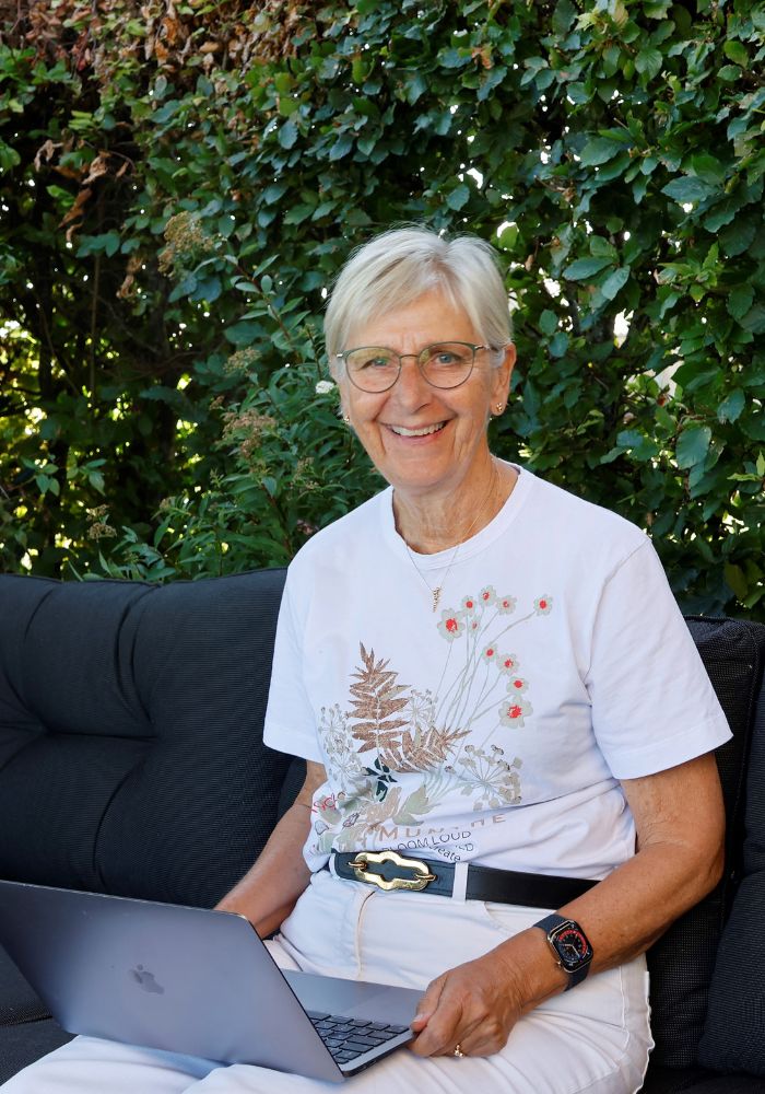 Ida Tangsgaard smiler ved et træ i haven