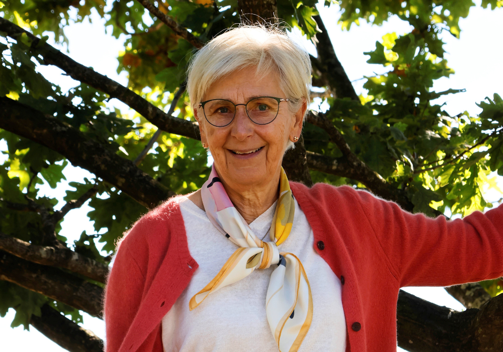 Ida Tangsgaard smiler ved et træ i haven